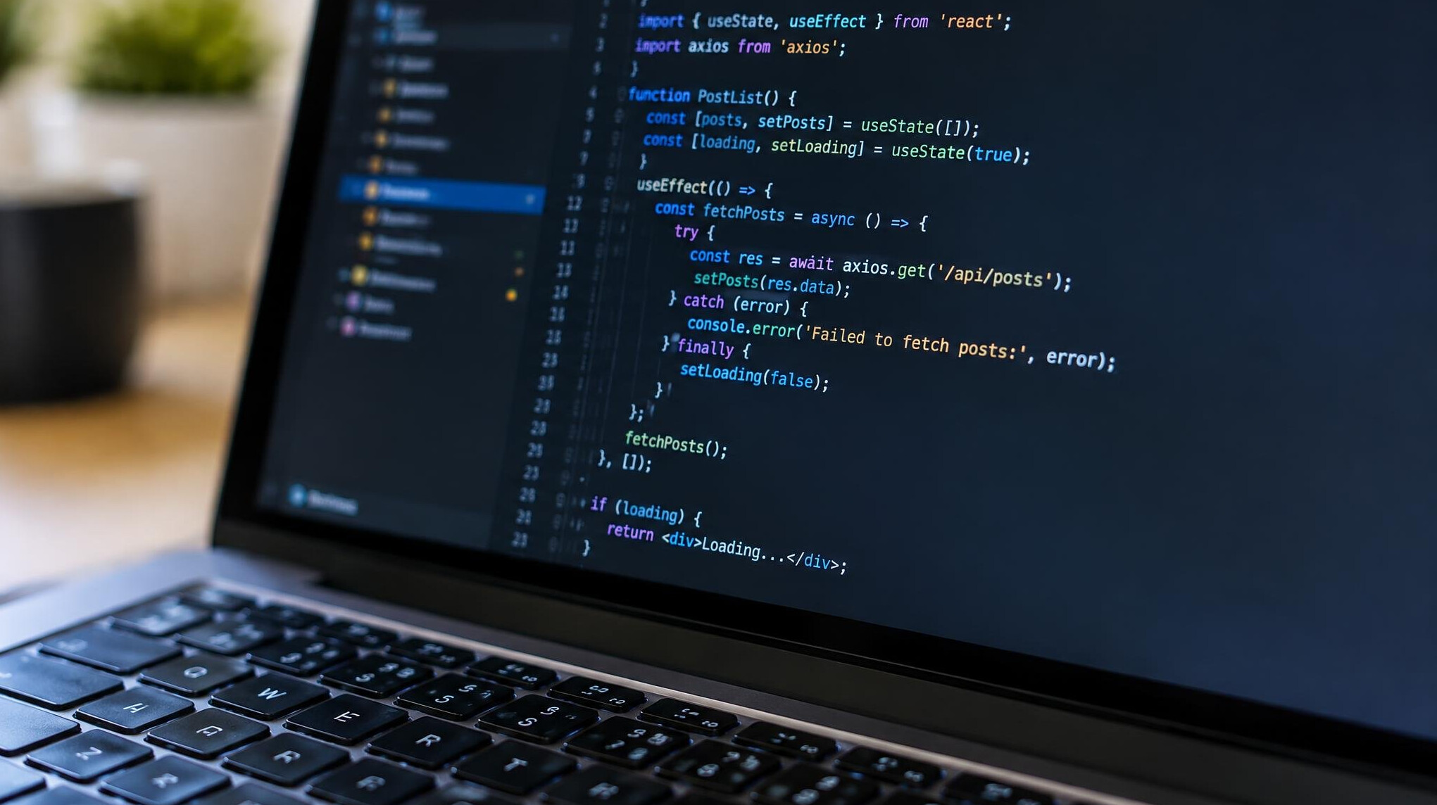Close-up of a laptop screen displaying programming code in a dark code editor