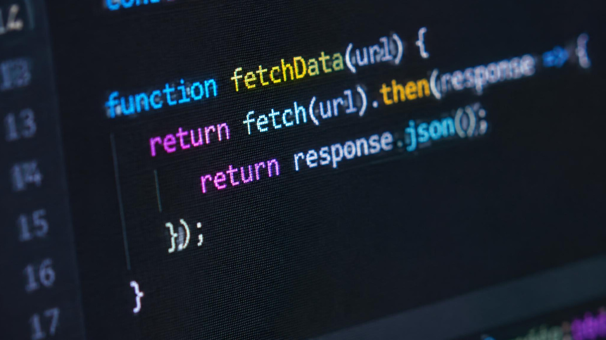 Extreme close-up of colorful programming code displayed on a monitor